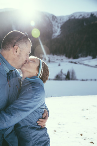 Italien, Vinschgau, Slingia, reifes Paar küsst sich in Winterlandschaft, lizenzfreies Stockfoto
