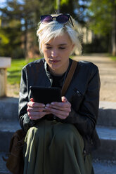 Porträt einer blonden Frau, die ein ebook liest - GIOF000735