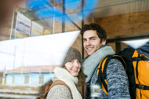 Porträt eines lächelnden jungen Paares am Bahnhof - HAPF000211