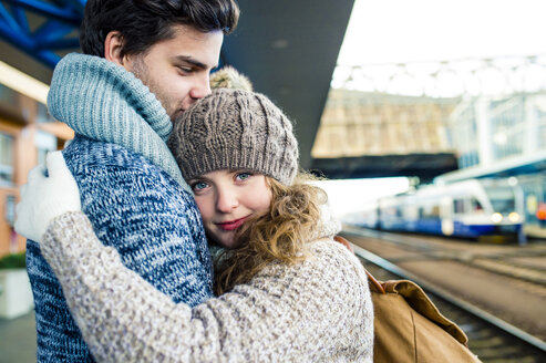Junges Paar umarmt sich auf dem Bahnsteig - HAPF000217