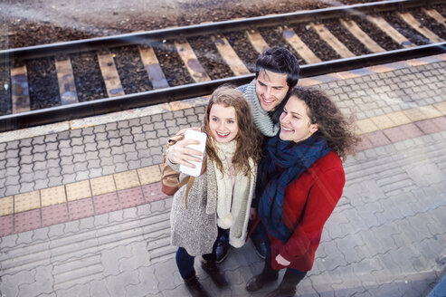 Drei Freunde auf dem Bahnsteig machen ein Selfie - HAPF000222