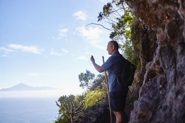 Spain, Canary Islands, La Gomera, hiker using gps navigation device - RHF001276