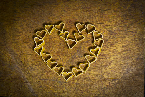 Heart-shaped noodles forming a heart on wood - MAEF011277