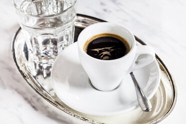 Cup of espresso and glass of water on metal tray - SBDF002689