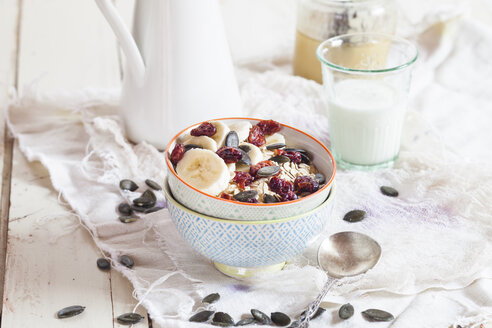 Schale mit Haferflocken, getrockneten Cranberries, Bananenscheiben und Kürbiskernen - SBDF002690