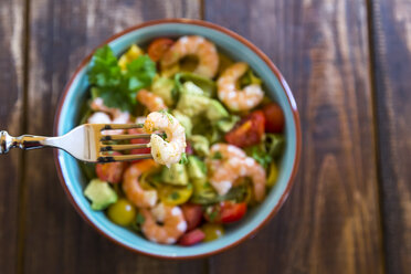 Noodle salad with avocado, tomato and shrimps in bowl on wood, fork with shrimp - SARF002547