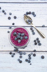 Glas Chia-Blaubeer-Pudding und Teelöffel auf Holz - LVF004521