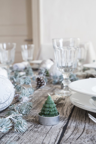 Teelicht in Form einer Tanne auf dem gedeckten Tisch zur Weihnachtszeit, lizenzfreies Stockfoto