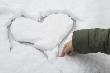 Finger of little boy carving a heart in snow on a car - DEGF000611