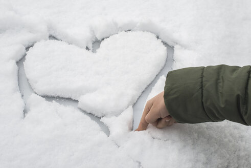 Finger eines kleinen Jungen, der ein Herz in den Schnee auf einem Auto schnitzt - DEGF000611