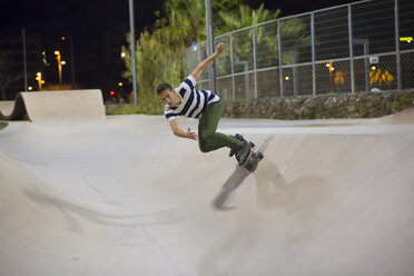 Spanien, Barcelona, junger Mann beim Skateboarden in einem nächtlichen Skatepark - SKCF000053
