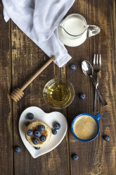 Stack of mini pancakes, blueberries, bowl of honey, milk and a cup of coffee - SARF002550