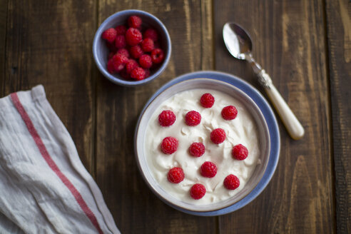 Joghurt mit Himbeeren in Schale auf Holz - SARF002556