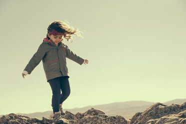 Spain, Consuegra, little girl walking on rocks in the mountains - ERLF000136