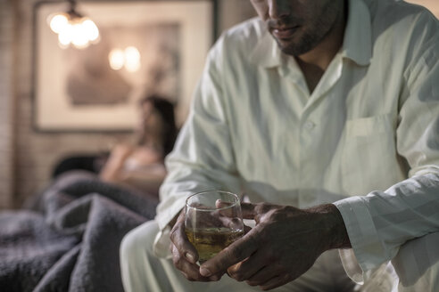 Man sitting on bed having a drink - ZEF008429