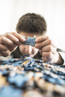 Die Hände eines Jungen halten zwei Puzzleteile - DEGF000622