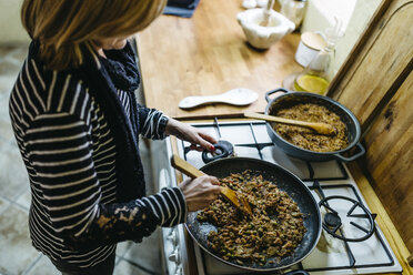 Woman cooking on gas stove in her kitchen - JRFF000426