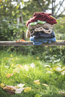 Stapel warmer Kleidung in einem Garten - DEGF000643