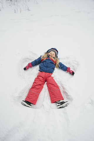 Little girl making a snow angel stock photo