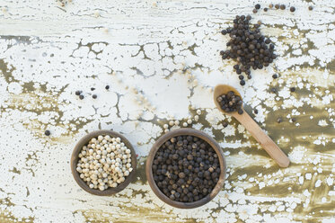 Two wooden bowls of black and white peppercorns - ASF005840