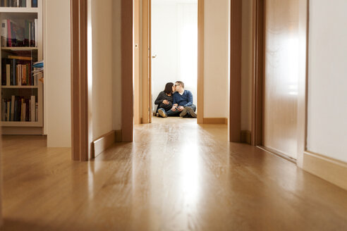 Werdende Eltern sitzen auf dem Boden der Wohnung und küssen sich - VABF000150