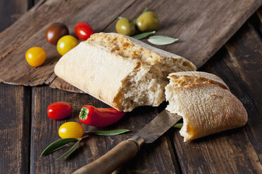 Ciabatta-Brot mit Tomaten, Mini-Paprika und Oliven auf Holz - CSF027165