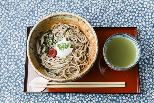 Schale mit Soba-Nudeln auf rotem Lackteller und Schale mit grünem Tee - FLF001307