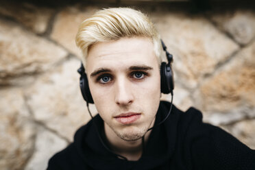 Porträt eines blonden jungen Mannes mit Kopfhörern - JRFF000445