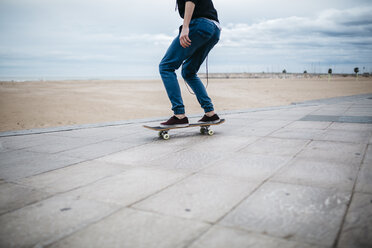 Spanien, Torredembarra, junger Skateboarder vor dem Strand, Teilansicht - JRFF000449