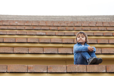 Portrait of little boy sitting on steps of an open-air theater - VABF000160