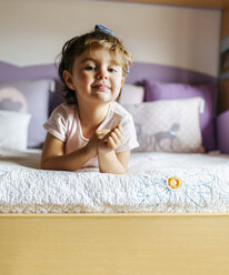 Portrait of little girl lying on her bed - MGOF001436