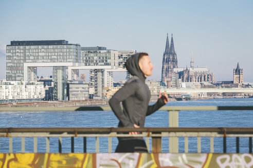 Deutschland, Köln, Junger Mann läuft am Flussufer - MADF000819