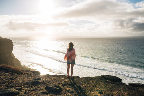 Spanien, Fuerteventura, El Cotillo, Rückenansicht einer Frau mit Blick auf das Meer bei Sonnenuntergang - GEMF000731