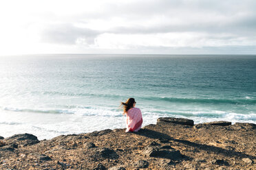 Spain, Fuerteventura, El Cotillo, back view of woman looking to the sea - GEMF000732