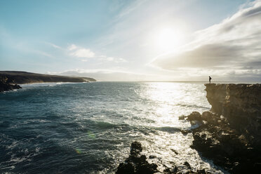 Spain, Canary Islands, Fuerteventura, La Pared, man standing on a cliff at sunset - GEMF000737