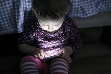 Kleinkind sitzt auf dem Boden und spielt mit Smartphone - HAPF000235