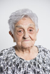 Portrait of sad senior woman in front of white background - RAEF000897