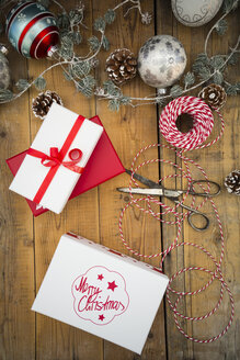 Weihnachtsdekoration und eingepackte Geschenke auf Holz - LVF004547