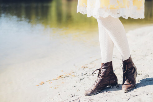 Legs of old-fashioned styled woman at water's edge - MJF001713