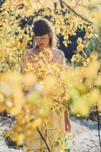 Junge Frau mit Blumenstrauß in herbstlicher Natur - MJF001716