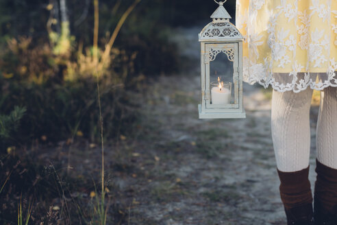 Old-fashioned styled woman holding storm lamp, partial view - MJF001723