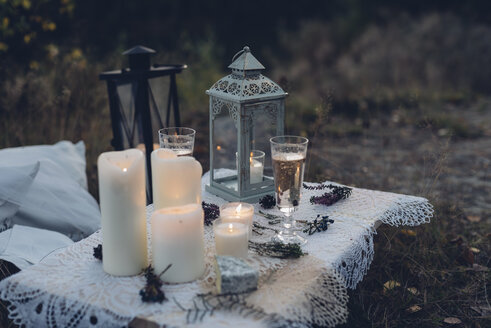 Two glasses of champagne, storm lamp and lighted candles on lace - MJF001734