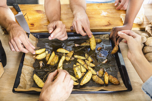 Freunde essen Kartoffelspalten vom Backblech - FMKF002306