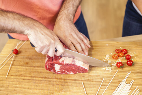 Schneiden eines Steaks auf einem Schneidebrett - FMKF002323