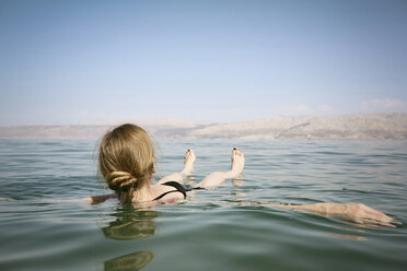 Israel, Frau schwimmt auf dem Wasser des Toten Meeres - REAF000058