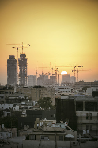 Israel, Tel Aviv, Stadtbild mit Kränen bei Sonnenuntergang, lizenzfreies Stockfoto