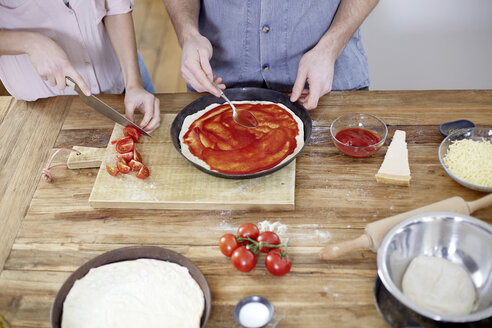 Ehepaar bereitet Pizza in der Küche zu - FMKF002373