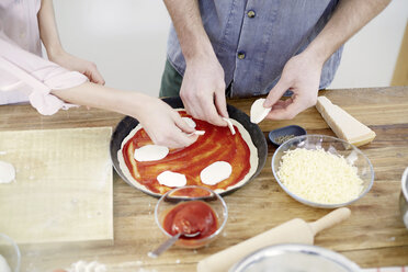 Couple preparing pizza in kitchen - FMKF002375