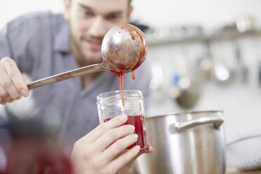 Couple filling jam into jars - FMKF002407