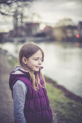 Deutschland, Landshut, lächelndes Mädchen vor der Isar stehend - SARF002578